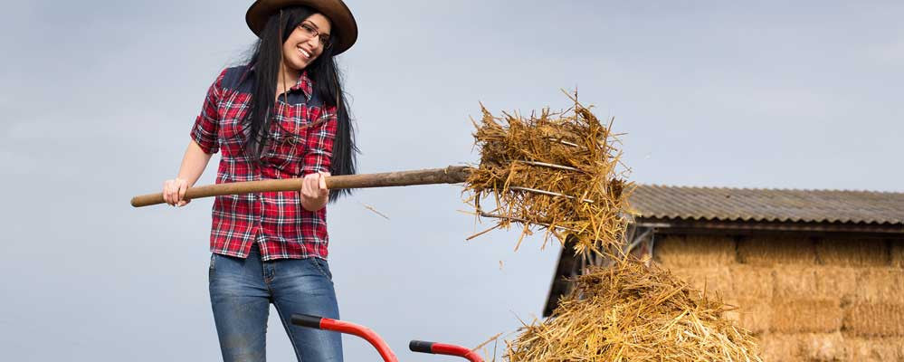  woman on farm spreading hay